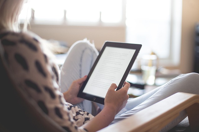ベッドで電子書籍リーダーを読んでいる人のイメージ